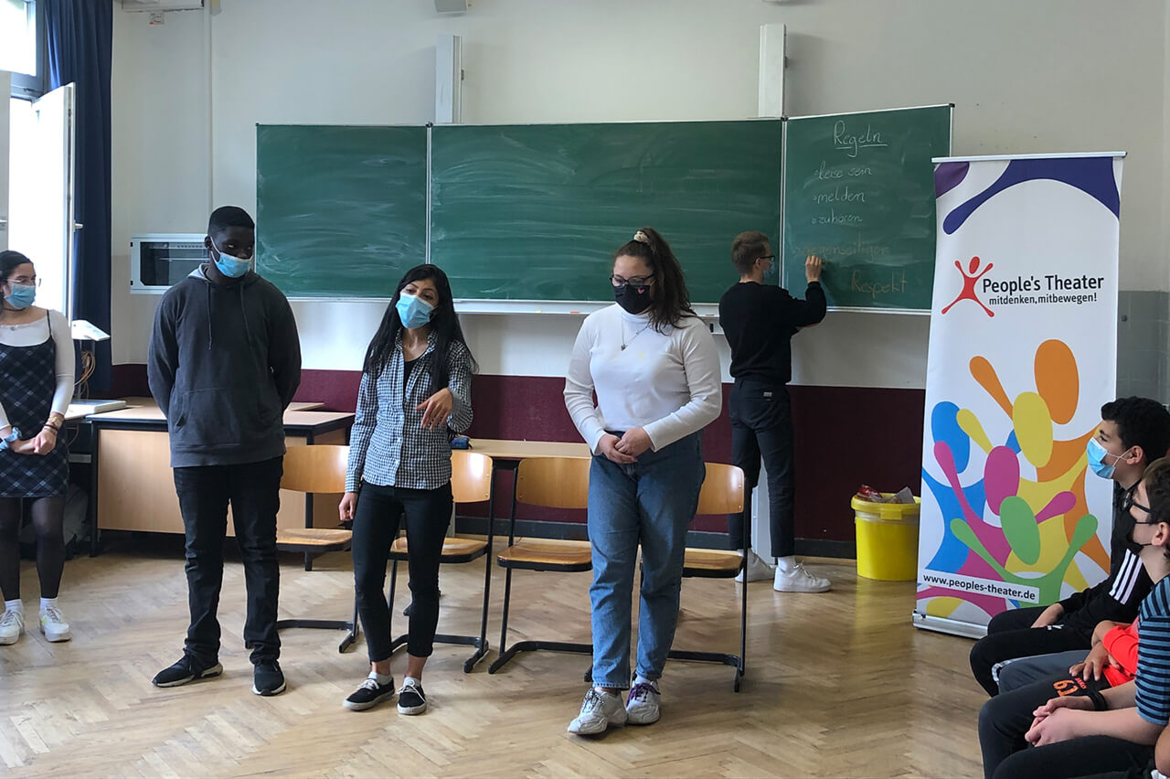 Tolerantes Dinslaken - Projekte 2021 - Szene beim Rollenspiel im Klassenraum - Theaterprobe der Schüler mit den Pädagogen vom interaktiven Mitmachtheater „People`s Theater“ - Bild 2 von 3