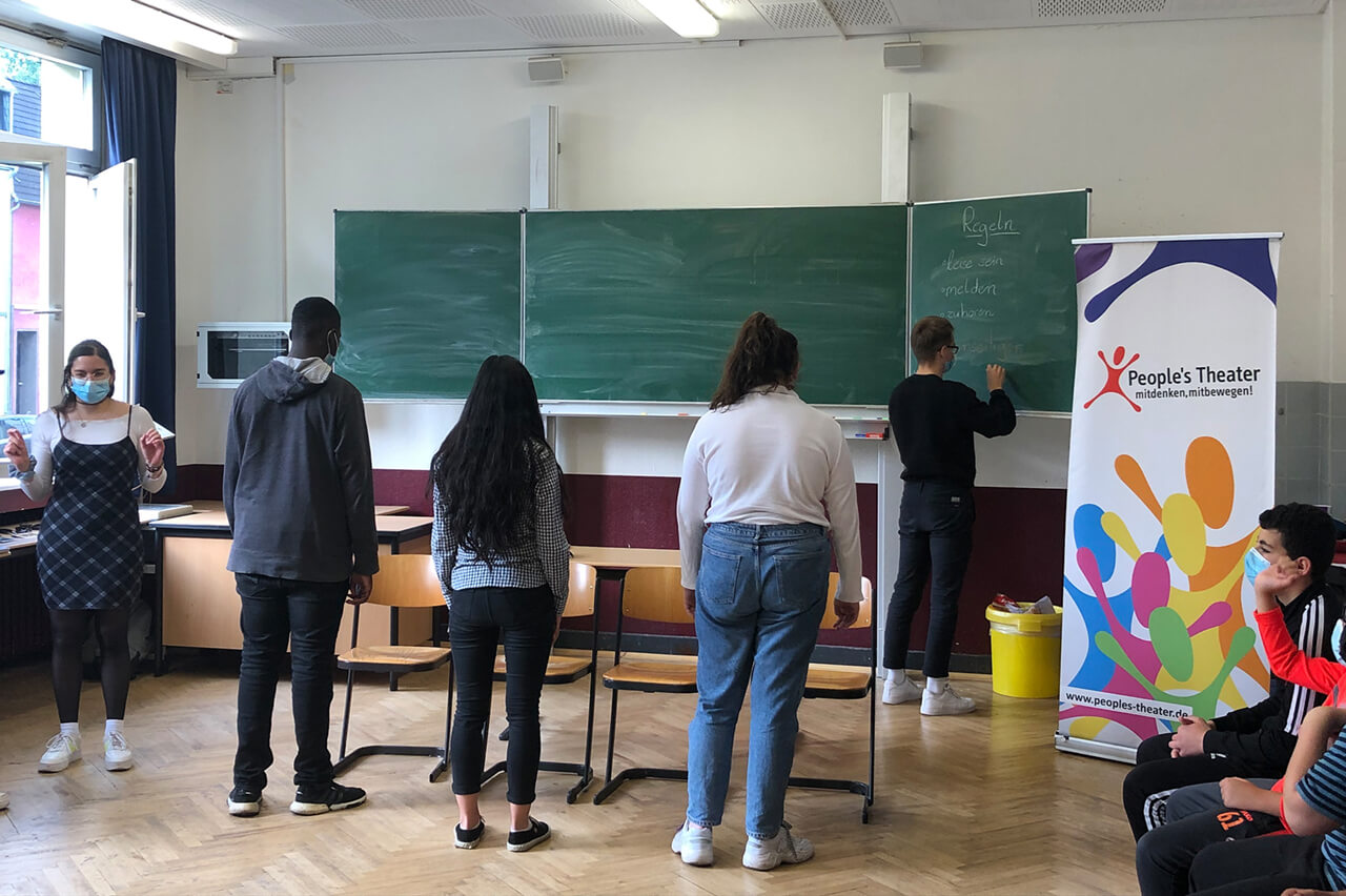 Tolerantes Dinslaken - Projekte 2021 - Szene beim Rollenspiel im Klassenraum - Theaterprobe der Schüler mit den Pädagogen vom interaktiven Mitmachtheater „People`s Theater“ - Bild 3 von 3